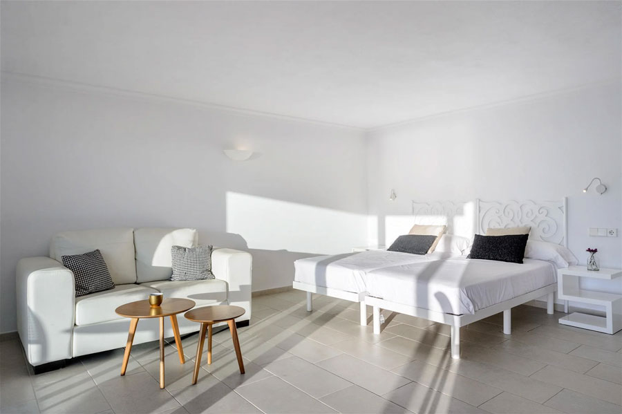 Habitación con dos camas individuales y un sofá de la Villa Sa Rota